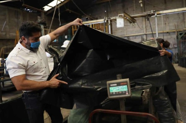 Fábrica mexicana pasa de hacer bolsas de basura a sacos para muertos de COVID