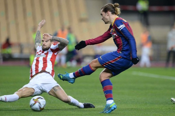 Athletic Bilbao's Spanish forward Ibai Gomez (L) vies with Barcelona's French midfielder Antoine Griezmann during the Spanish Super Cup final football match between FC Barcelona and Athletic Club Bilbao at La Cartuja stadium in Seville on January 17, 2021. (Photo by CRISTINA QUICLER / AFP)