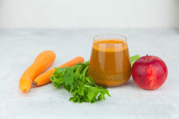 carrot juice in glass on wooden table