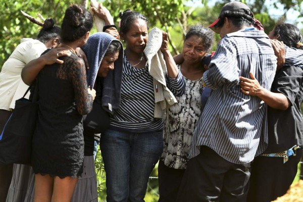 Relatives of one of the victims of a boat accident mourn his death during his funeral at Prumitara Village, near Puerto Lempira, Honduras, on July 5, 2019. - Families of the 27 people who died after a Honduran fishing boat sank have started receiving the bodies of their relatives, as the country's president ordered a probe into the incident. (Photo by ORLANDO SIERRA / AFP)