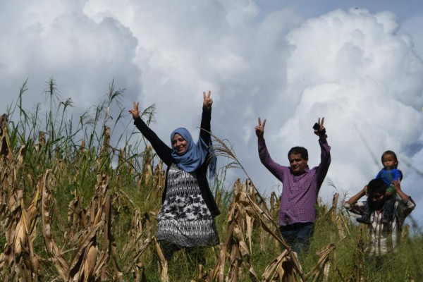 Yemeni journalist and Nobel Peace Prize laureate Tawakkol Karman (2nd R)crosses a maize plantation in her way to Gualcarque river in the Rio Blanco mountain, 150 km from Tegucigalpa on October 21, 2017. Nobel prize laureates, Tawakkol Karman (Yemen) and Shirin Ebadi (Iran) visit the Gualcarque river in western Honduras, where late activist Berta Caceres was murdered. / AFP PHOTO / ORLANDO SIERRA