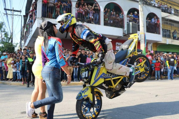 Un joven motociclista detiene su marcha para lanzar un beso a una joven durante la feria de El Progreso, Yoro, zona norte de Honduras.