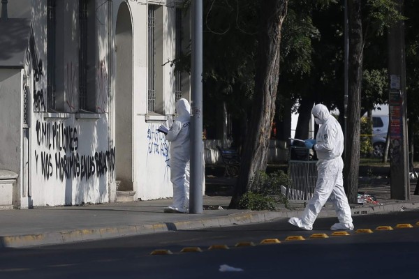 Police personnel work in the scene where a bomb alert occured and a graffiti against the pontiff was written at the Poor Christ Sanctuary in Santiago on January 12, 2018 ahead of Pope Francis upcoming visit to Chile. Three Catholic churches were attacked early Friday morning in Santiago a few days before Pope Francis arrives in the country from January 15 to 18. / AFP PHOTO / PABLO VERA