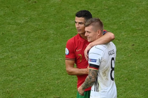 Portugal's forward Cristiano Ronaldo (L) greets Germany's midfielder Toni Kroos (R) at the end of the UEFA EURO 2020 Group F football match between Portugal and Germany at Allianz Arena in Munich on June 19, 2021. (Photo by Matthias Hangst / POOL / AFP)