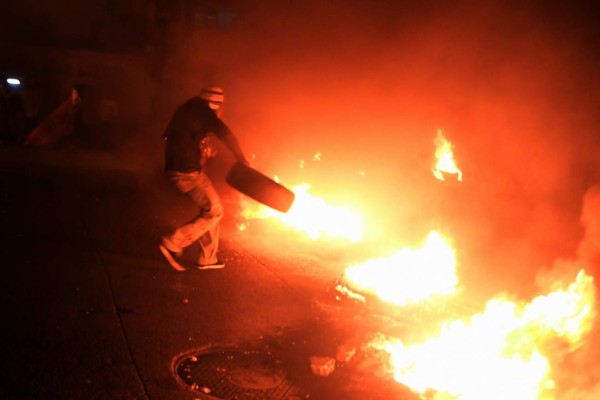 Supporters of presidential candidate for the opposition Alliance against Dictatorship party Salvador Nasralla set up burning barricades as they protest in Tegucigalpa on December 19, 2017.Honduran President Juan Orlando Hernandez called on the opposition Tuesday to hold talks with his government, after he was declared the winner of a bitterly disputed election. A key figure in Nasralla's leftwing Opposition Alliance Against the Dictatorship coalition, ex-president Manuel Zelaya, urged supporters to keep up nationwide demonstrations, albeit peacefully. / AFP PHOTO / ORLANDO SIERRA