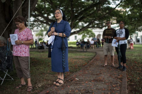 Catholic worshippers attend a 'prayers for peace' rally marking the 100th anniversary of Our Lady of Fatima in Hagatna on August 13, 2017.The Catholic faithful in Guam led prayers for peace on August 13 in the face of a threatened North Korean missile attack, although most on the western Pacific island continued to believe there was nothing to be afraid of. / AFP PHOTO / Ed JONES