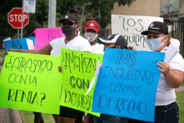 Unas voluntarias de la organización comunitaria Mujeres Trabajadoras Inmigrantes sostienen carteles durante un recorrido para ofrecer información sobre los derechos de los inquilinos en un barrio de alta población latina en el suroeste de Houston, Texas. EFE/Alicia L. Pérez