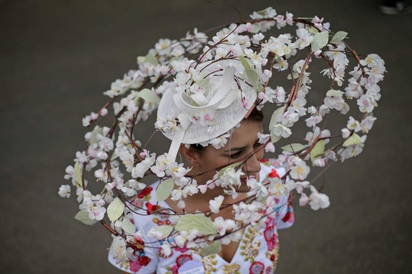 A racegoer poses on day one of the Royal Ascot horse racing meet, in Ascot, west of London, on June 19, 2018. The five-day meeting is one of the highlights of the horse racing calendar. Horse racing has been held at the famous Berkshire course since 1711 and tradition is a hallmark of the meeting. Top hats and tails remain compulsory in parts of the course while a daily procession of horse-drawn carriages brings the Queen to the course. / AFP PHOTO / Daniel LEAL-OLIVAS