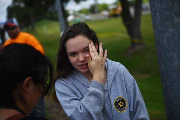 Student Tori White speaks with reporters outside Santa Fe High School on May 19, 2018, in Santa Fe, Texas.Ten people, mostly students, were killed when a teenage classmate armed with a shotgun and a revolver opened fire at the school on May 18. The gunman, arrested on murder charges, was identified as Dimitrios Pagourtzis, a 17-year-old junior at Santa Fe High School. He is being held on capital murder charges, meaning he could face the death penalty. / AFP PHOTO / Brendan Smialowski