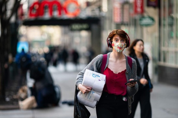 NEW YORK, NY - MARCH 13: A woman wearing a protective mask carries a toilet paper package on the street on March 13, 2020 in New York City. President Donald Trump is expected to declare national emergency over coronavirus crisis today. There are at least 95 confirmed cases in New York City. Jeenah Moon/Getty Images/AFP== FOR NEWSPAPERS, INTERNET, TELCOS & TELEVISION USE ONLY ==