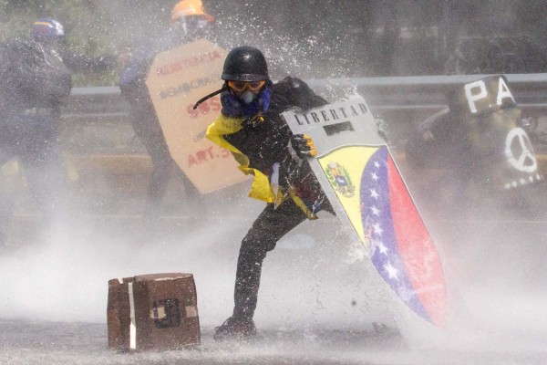 CAR71. CARACAS (VENEZUELA), 10/05/2017 - Manifestantes se enfrentan a la Guardia Nacional Bolivariana hoy, miércoles 10 de mayo de 2017, en Caracas (Venezuela). Efectivos de las fuerzas de seguridad del Estado venezolano dispersaron hoy con gas lacrimógeno la manifestación de la oposición que pretendía llegar hasta la sede del Tribunal Supremo de Justicia. Un hombre que resultó herido el pasado lunes murió hoy según informó el Ministerio Público de Venezuela, lo que eleva a 38 los fallecidos durante los últimos 40 días en los que una ola de protestas, a favor y en contra del Gobierno del presidente Nicolás Maduro, que también ha dejado cientos de heridos y detenidos. EFE/MIGUEL GUTIERREZ