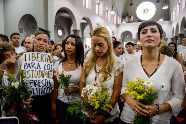 San Cristobal's Mayor Patricia de Ceballos (R), wife of the imprisoned former mayor of San Cristobal, Daniel Ceballos, Lilian Tintori (2nd R), wife of jailed opposition leader Leopoldo Lopez take part in a vigil in the Chiquinquira church, in Caracas on June 6, 2015. AFP PHOTO / FEDERICO PARRA