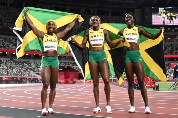 Winner Jamaica's Elaine Thompson-Herah (C) poses with second-placed Jamaica's Shelly-Ann Fraser-Pryce (L) and third-placed Jamaica's Shericka Jackson (R) after the women's 100m final during the Tokyo 2020 Olympic Games at the Olympic Stadium in Tokyo on July 31, 2021. (Photo by Jewel SAMAD / AFP)