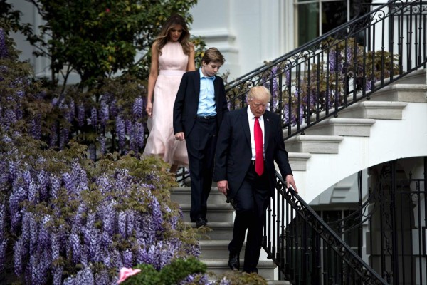 (FILES) This file photo taken on April 17, 2017 shows L-R) US First Lady Melania Trump, Barron Trump and US President Donald Trump walking to the Easter Egg Roll on the South Lawn of the White House in Washington, DC.Donald Trump's youngest son Barron will attend a private school in Maryland after he and his mother move into the White House this summer, the first lady announced May 15, 2017.The announcement will likely save New York tens of thousands of dollars a day in police costs incurred by 11-year-old Barron and his mother Melania remaining in Manhattan while he finishes the semester at his current school. / AFP PHOTO / Brendan Smialowski