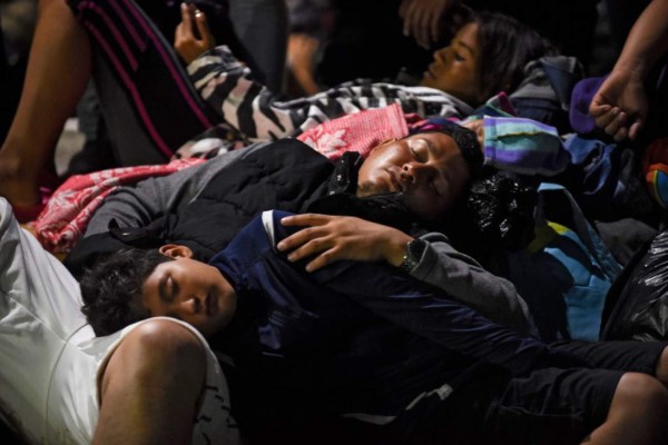 Honduran migrants heading in a caravan to the United States, rest in Ciudad Tecun Uman, Guatemala, in the border with Mexico, on October 19, 2018. - US President Donald Trump threatened on October 18 to send the military to close its southern border if Mexico fails to stem the 'onslaught' of migrants from Central America, in a series of tweets that blamed Democrats ahead of the midterm elections. (Photo by JOHAN ORDONEZ / AFP)