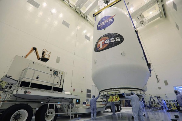 In this image obtained from NASA, technicians assist as the SpaceX payload fairing containing the NASAs Transiting Exoplanet Survey Satellite (TESS) is moved by crane to a transporter on April 11, 2018, inside the Payload Hazardous Servicing Facility at NASAs Kennedy Space Center, Florida.SpaceX postponed the launch of NASA's new planet-hunting mission on April 16, 2018, in order to verify the Falcon 9 rocket's navigation systems, the California-based company said. The next opportunity to blast off the $337 million satellite will be April 18. / AFP PHOTO / Kim SHIFLETT / RESTRICTED TO EDITORIAL USE - MANDATORY CREDIT 'AFP PHOTO / NASA / Kim SHIFLETT' - NO MARKETING NO ADVERTISING CAMPAIGNS - DISTRIBUTED AS A SERVICE TO CLIENTS