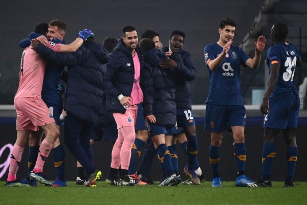 FC Porto's players celebrate at the end of the UEFA Champions League round of 16 second leg football match between Juventus Turin and FC Porto on March 9, 2021 at the Juventus stadium in Turin. (Photo by Marco BERTORELLO / AFP)