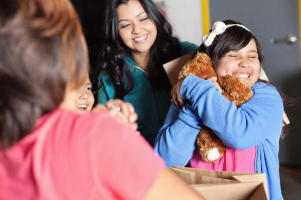 Cute girl holding a teddy bear that's been given.