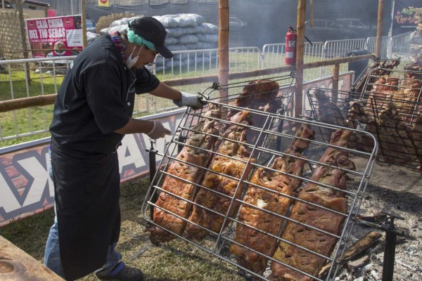 Lima, Peru - September 4, 2015: A man perparing Pachamanca meat at the annual Mistura Food Festival