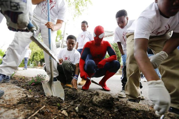 Un hombre vestido de 'Spiderman' (c) ayuda a unos estudiantes de una academia KIPP (acrónimo de Programa Conocimiento es Poder) a plantar unas flores con motivo de la celebración de la 44 edición del Día Internacional de la Madre Tierra en Atlanta, Estados Unidos, hoy, martes 22 de abril de 2014. EFE