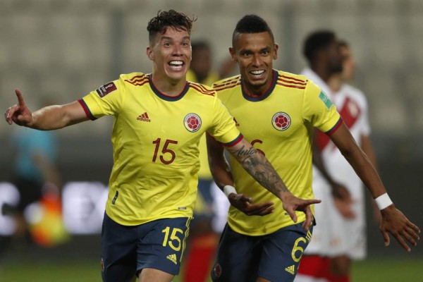 Colombia's Mateus Uribe (L) celebrates with teammate William Tesillo after scoring a header against Peru during their South American qualification football match for the FIFA World Cup Qatar 2022 at the National Stadium in Lima on June 3, 2021. (Photo by Paolo Aguilar / POOL / AFP)