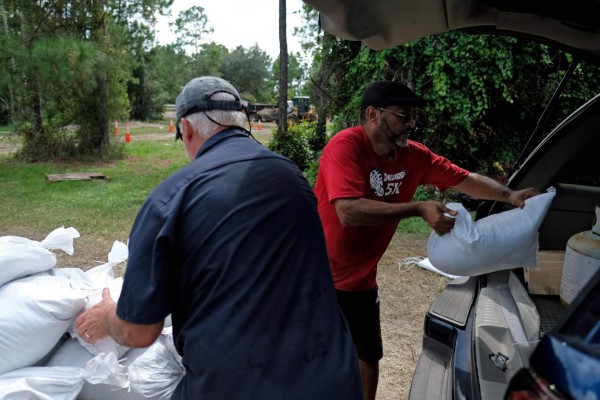Residents load sandbags to protect their homes in Deltona, Florida, as they prepare for Hurricane Dorian, on August 31, 2019. - Hurricane Dorian changed course slightly on Saturday, possibly putting it on track to hit the Carolinas rather than Florida as previously forecast, after a dangerous blast through the Bahamas. Meteorologists said Dorian has grown into an extremely dangerous Category 4 storm as it heads toward land. (Photo by Ricardo ARDUENGO / AFP)