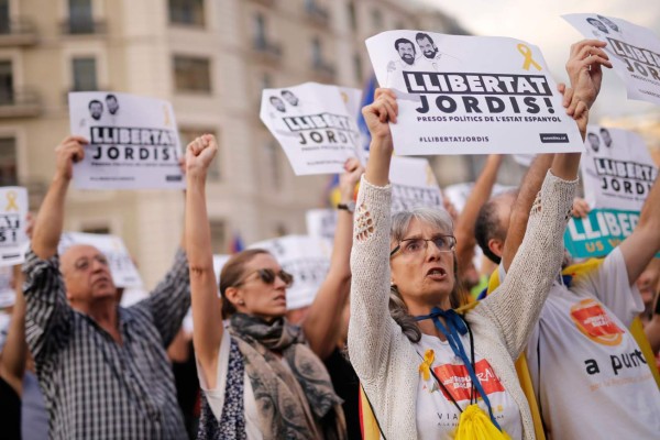 Protesters hold signs reading 'Free the Jordis' during a demonstration in Barcelona on October 21, 2017 in support of two separatist leaders Jordi Sanchez and Jordi Cuixart, who have been detained pending an investigation into sedition charges.Spain announced that it will move to dismiss Catalonia's separatist government and call fresh elections in the semi-autonomous region in a bid to stop its leaders from declaring independence. / AFP PHOTO / PAU BARRENA