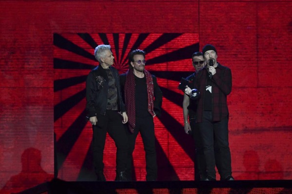 Irish rock band U2, Bono (2L), The Edge (R), Adam Clayton (L) and Larry Mullen Jr (2R), accept the global icon award during the 2017 MTV Europe Music Awards (EMA) at Wembley Arena in London on November 12, 2017. / AFP PHOTO / Ben STANSALL