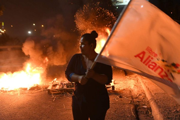 Supporters of presidential candidate for the opposition Alliance against Dictatorship party Salvador Nasralla, protest in Tegucigalpa, on December 17, 2017.The coordinator of the Opposittion Alliance against Dictatorship party, Manuel Zelaya, called to national mobilization, of the declaration as elected Honduran president of Juan Orlando Hernandez from the Supreme Electoral Tribunal. / AFP PHOTO / Orlando SIERRA