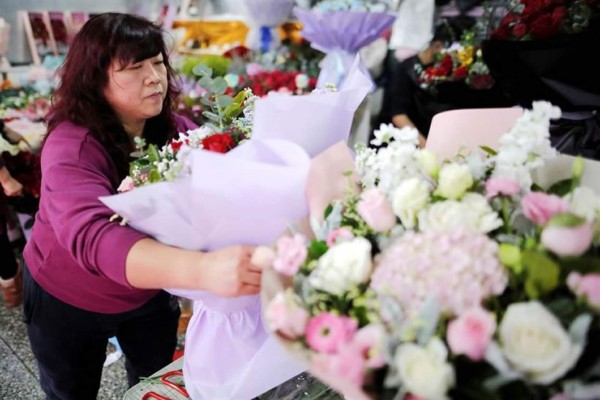 Una florista coloca ramos de flores en su tienda, en Pekín, China. EFE/Archivo