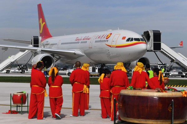 Drummers look at the first Airbus A330 plane to be delivered before the inauguration ceremony of the Airbus A330 Completion and Delivery Centre in Tianjin, China on September 20, 2017.Aerospace giant Airbus inaugurated a completion center for A330 widebody aircraft, which will provide cabin equipment, furnishing and exterior paint for the planes bought by Chinese airlines - a new selling point for the European group in the crucial and fast expanding Chinese market, where it experiences tough competition with its US rival Boeing. / AFP PHOTO / GREG BAKER