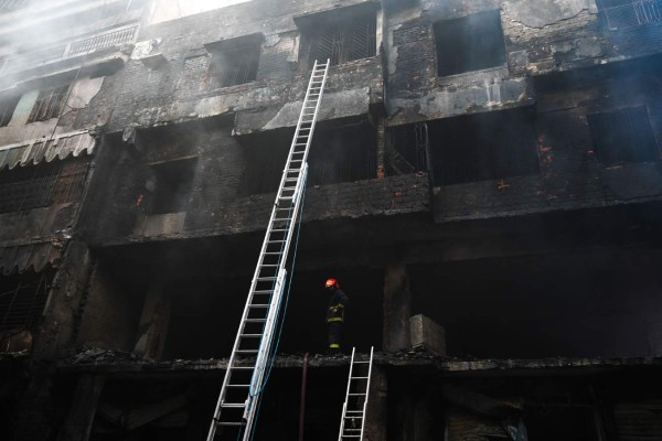 A firefighter inspects a burnt building after a fire broke out in Dhaka on February 21, 2019. - At least 69 people have died in a huge blaze that tore through apartment buildings also used as chemical warehouses in an old part of the Bangladeshi capital Dhaka, fire officials said on February 21. (Photo by Munir UZ ZAMAN / AFP)