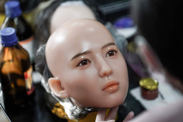 This photo taken on February 1, 2018 shows a worker painting the face of a silicone doll at a factory of EXDOLL, a firm based in the northeastern Chinese port city of Dalian.With China facing a massive gender gap and a greying population, a company wants to hook up lonely men and retirees with a new kind of companion: 'Smart' sex dolls that can talk, play music and turn on dishwashers. / AFP PHOTO / FRED DUFOUR / TO GO WITH China-sex-lifestyle, FOCUS by Joanna CHIU