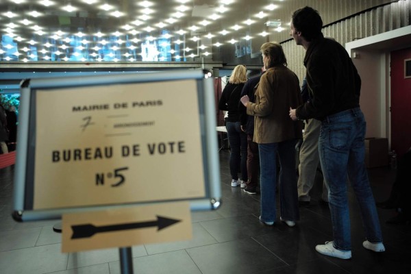 Voters queue at a polling station in Paris on April 23, 2017, during the first round of the Presidential election. / AFP PHOTO / Philippe LOPEZ