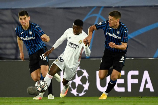 Real Madrid's Brazilian forward Vinicius Junior (C) vies with Atalanta's Ukrainian midfielder Ruslan Malinovskiy (L) and Atalanta's Danish defender Joakim Maehle during the UEFA Champions League round of 16 second leg football match between Real Madrid CF and Atalanta at the Alfredo di Stefano stadium in Valdebebas, on the outskirts of Madrid on March 15, 2021. (Photo by PIERRE-PHILIPPE MARCOU / AFP)