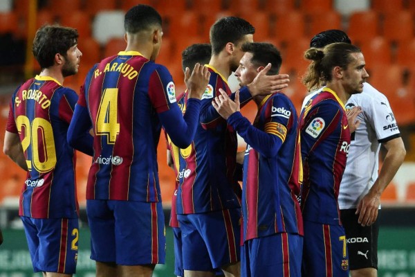 Barcelona players celebrate their victory at the end of the Spanish League football match between Valencia and Barcelona at the Mestalla stadium in Valencia on May 2, 2021. (Photo by JOSE JORDAN / AFP)