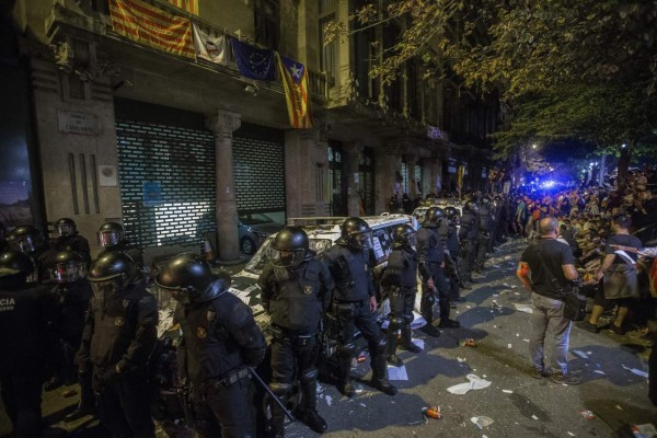 GRA003. BARCELONA, 21/09/2017.- Agentes de los Mossos d'Esquadra custodian las puertas de la sede de la consellería de Economía de la Generalitat en cuyo interior se encontraba un grupo de agentes de la Guardia Civil que realizaban un registro con motivo del 1-O desde las ocho de la mañana de ayer, y que no podían abandonar la sede debido a la concentración de miles de personas en el exterior. EFE/Quique García