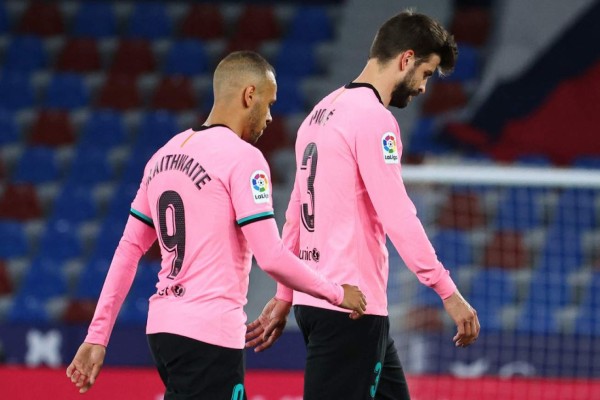 Barcelona's Danish forward Martin Braithwaite and Barcelona's Spanish defender Gerard Pique react at the end of the Spanish league football match Levante UD against FC Barcelona at the Ciutat de Valencia stadium in Valencia on May 11, 2021. (Photo by JOSE JORDAN / AFP)