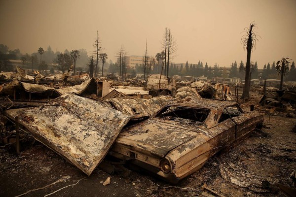 SANTA ROSA, CA - OCTOBER 09: The remains of a fire damaged homes and cars at the Journey's End Mobile Home Park on October 9, 2017 in Santa Rosa, California. Ten people have died in wildfires that have burned tens of thousands of acres and destroyed over 1,500 homes and businesses in several Northen California counties. Justin Sullivan/Getty Images/AFP== FOR NEWSPAPERS, INTERNET, TELCOS & TELEVISION USE ONLY ==