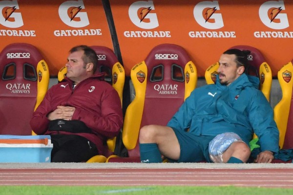 AC Milan's Swedish forward Zlatan Ibrahimovic (R) sits on the substitutes' bench with an ice pack on his left tigh, after being injured during the Italian Serie A football match AS Roma vs AC Milan on February 28, 2021 at the Olympic stadium in Rome. (Photo by Tiziana FABI / AFP)