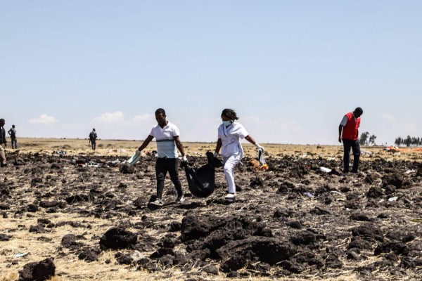 Rescue team carry collected bodies in bags at the crash site of Ethiopia Airlines near Bishoftu, a town some 60 kilometres southeast of Addis Ababa, Ethiopia, on March 10, 2019. - An Ethiopian Airlines Boeing 737 crashed on March 10 morning en route from Addis Ababa to Nairobi with 149 passengers and eight crew believed to be on board, Ethiopian Airlines said. (Photo by Michael TEWELDE / AFP)