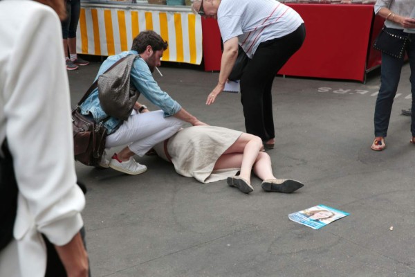 Bystanders gives assistance after Les Republicains (LR) party candidate Nathalie Kosciusko-Morizet collapsed while campaigning in the 5th arrondissement in Paris on June 15, 2017, ahead of the second round of the French legislative election. / AFP PHOTO / GEOFFROY VAN DER HASSELT