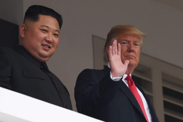 (FILES) This file photo taken on June 12, 2018 shows US President Donald Trump (R) waving as he and North Korea's leader Kim Jong Un look out from a veranda during their historic US-North Korea summit, at the Capella Hotel on Sentosa island in Singapore. - US President Donald Trump said on February 5, 2019 that he would hold his long-awaited second summit with North Korean leader Kim Jong Un on February 27 and 28 in Vietnam. (Photo by SAUL LOEB / AFP)