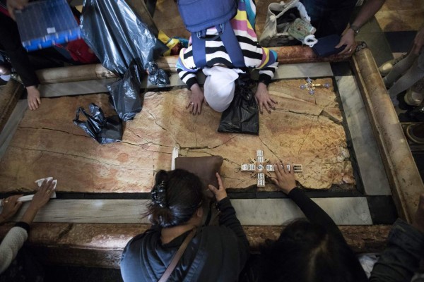Jerusalem (Israel), 14/04/2019.- Visitors pray by the Stone of the Anointing in the Church of the Holy Sepulchre in Jerusalem's Old City, 14 April 2019.Christian pilgrim mark the Palm Sunday as many Christian churches symbolically marks the biblical account of the entry of Jesus Christ into Jerusalem, signaling the start of the Holy Week before Easter. (Estados Unidos, Jerusalén) EFE/EPA/ABIR SULTAN