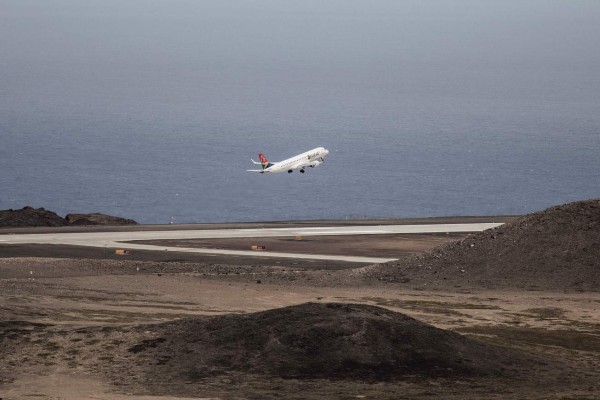 TOPSHOT - A picture taken on October 15, 2017 shows the first Inaugural Commercial plane from Johannesburg taking off at the newly built Saint Helena Airport in the tropical island of Saint Helena, in the South Atlantic Ocean and part of the British Overseas Territory.After five years of construction, controversy and embarrassing delays due to high winds, an airport built at a cost of £285 million (318 million euros) will welcome its first routine flight from Johannesburg. / AFP PHOTO / GIANLUIGI GUERCIA