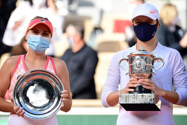 Second placed Sofia Kenin of the US (L) and winner Poland's Iga Swiatek celebrate with their trophies during the podium ceremony after the women's singles final tennis match, at the Philippe Chatrier court, on Day 14 of The Roland Garros 2020 French Open tennis tournament in Paris on October 10, 2020. (Photo by MARTIN BUREAU / AFP)