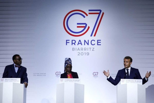 French President Emmanuel Macron (R), African Development Bank President Akinwumi Adesina (L) and UNICEF Ambassador Angelique Kidjo (C) speak during a press conference on the AWAFA (Affirmative Finance Action for Women in Africa) program during the G7 summit in Biarritz, south-west France on August 25, 2019, on the second day of the annual summit attended by the leaders of the world's seven richest democracies, Britain, Canada, France, Germany, Italy, Japan and the United States. (Photo by Ian LANGSDON / POOL / AFP)