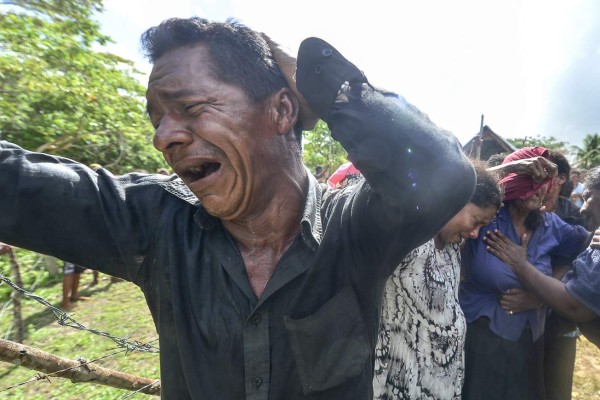 Relatives of one of the victims of a boat accident mourn his death during his funeral at Prumitara Village, near Puerto Lempira, Honduras, on July 5, 2019. - Families of the 27 people who died after a Honduran fishing boat sank have started receiving the bodies of their relatives, as the country's president ordered a probe into the incident. (Photo by ORLANDO SIERRA / AFP)