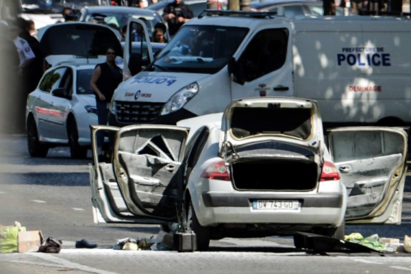 EDITORS NOTE: Graphic content / A car with all doors and trunk opened is pictured in a Police sealed off area of the Champs-Elysees avenue in Paris, on June 19, 2017, after a car crashed into a police van before bursting into flames, with the driver being armed, probe sources said.A car burst into flames after it crashed into a police van on the Champs-Elysees avenue in Paris on June 19, police and investigators said, adding that the driver was armed and it appeared to be a 'deliberate' act. Authorities said the driver was 'most probably dead'. / AFP PHOTO / Thomas SAMSON
