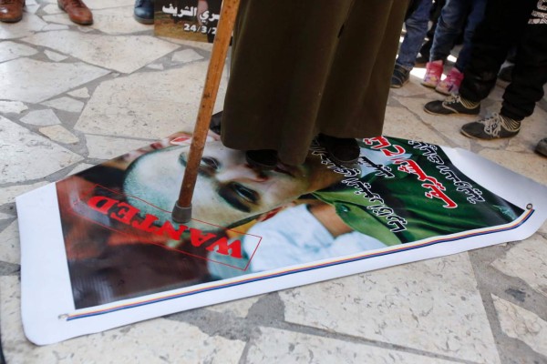A Palestinian woman steps during a demonstration on a portrait of Israeli soldier Elor Azaria, who in March 2016 shot dead wounded alleged Palestinian assailant Abdul Fatah al-Sharif as he lay on the ground, in the occupied West Bank city of Hebron, on February 21, 2017.Israeli Judge Maya Heller handed down the sentence a month after Elor Azaria, 21, was found guilty of manslaughter for killing Palestinian Abdul Fatah al-Sharif as he lay on the ground in the southern occupied West Bank. / AFP PHOTO / HAZEM BADER